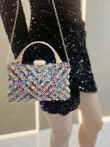 Dettaglio borsa da sera con strass colorati e un elegante manico in metallo dorato