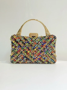 Vista macro di strass colorati e chiusura in metallo dorato sulla pochette da sera elegante