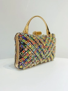 Dettaglio di una lussuosa pochette da sera con strass colorati e manico dorato