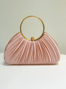 Detail of pink satin evening bag featuring pleated texture and large gold ring handle