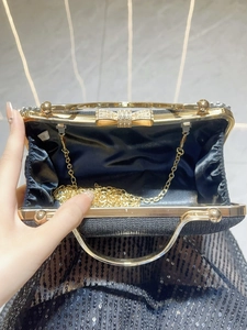 Sparkling black sequin evening clutch bag with gold trim and crystal bow clasp detail
