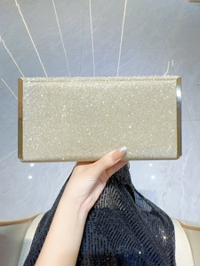 Detail of elegant gold sequined evening clutch with polished metal edges for parties