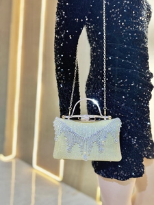 Macro detail of champagne gold evening bag with rhinestone fringe and chain strap