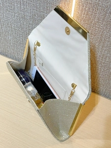 Detail of gold glitter envelope clutch with interior storage for phone and cosmetics