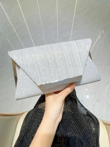 Detail of silver sequin evening clutch featuring metallic trim and glittery texture