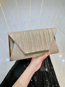 Detailed view of champagne gold glitter evening clutch with elegant metallic buckle