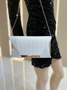 Detail of silver pleated glitter evening clutch with elegant metallic chain strap