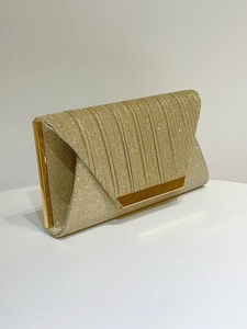 Detail of elegant gold evening clutch with glitter texture and metallic gold trim