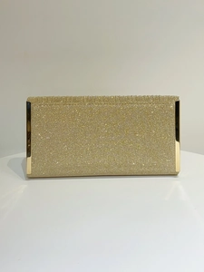 Close-up of glittering gold champagne clutch bag with shiny metallic frame and texture