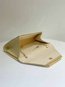 Macro shot of gold sequin evening clutch bag showing inner lining and gold chain strap