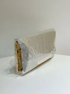 Detail of elegant gold evening clutch with delicate metallic fabric and gold chain strap