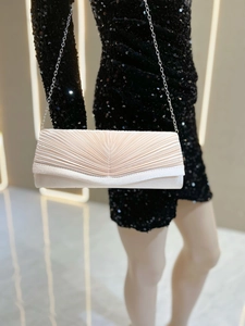 Détails plissés et finition satinée champagne d'une pochette de soirée élégante