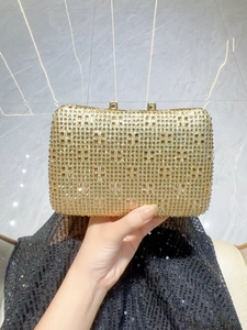 Close-up of golden rhinestone clutch evening bag with elegant metal frame and top clasp