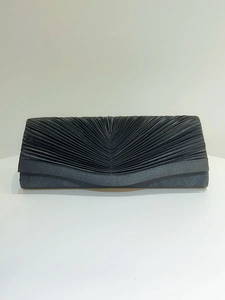 Détail d'une pochette de soirée noire élégante avec texture plissée et design radial