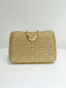 Detail of champagne gold evening clutch with rhinestones and metal crescent handle