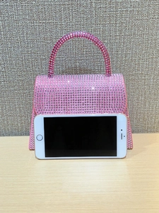 Pink rhinestone hourglass evening bag shown next to a smartphone for size reference