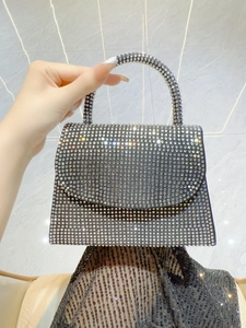 Close-up of sparkling rhinestones on a black mini evening handbag with top handle