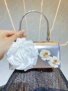 Detail of silver metallic evening bag with white satin 3D rose and pearl flower accents