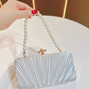 Silver pleated evening clutch bag featuring a pearl handle and gold twist lock detail