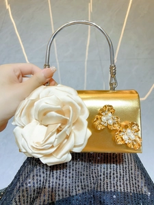 Detail of gold evening bag with large satin rose flower, pearls, and crystal accents