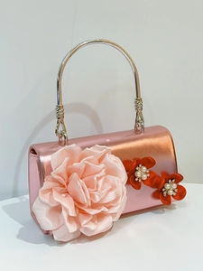 Close-up of pink metallic clutch with silk flowers, pearls and rhinestones detail