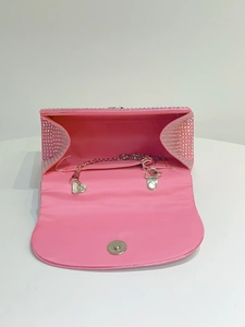 Detail of pink rhinestone evening clutch featuring silver chain strap and magnetic closure