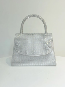 Close-up of a sparkling silver rhinestone evening handbag with a matching jeweled handle