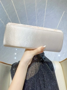 Détail d'une élégante pochette de soirée en satin plissé champagne pour les mariages