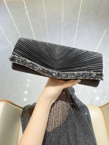 Détail d'une pochette de soirée en satin noir plissé avec bordure en strass étincelants