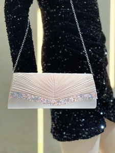 Détail de la pochette de soirée en satin champagne avec plis et bordure en strass brillant
