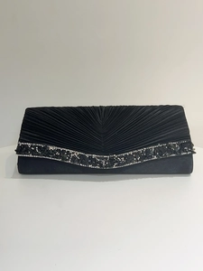 Détail d'une pochette de soirée noire avec plis élégants et bordure de pierres