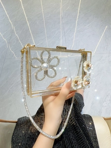 Transparent acrylic evening clutch bag with golden chain and pearl flower detail