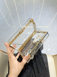 Transparent acrylic evening clutch with gold hardware and white floral pearl accents