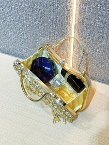 Internal view of gold rhinestone evening clutch showing capacity for makeup and perfume