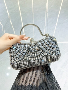 Detailed view of luxury black evening clutch with sparkling silver rhinestones and crystal tassels