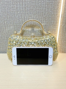 Golden evening clutch bag with rhinestones, tassels, and a top handle for weddings