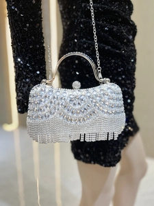 Detailed view of silver evening bag with rhinestone tassels and sparkling diamond texture