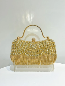 Detail of evening clutch with champagne rhinestones, fringe tassels and golden handle
