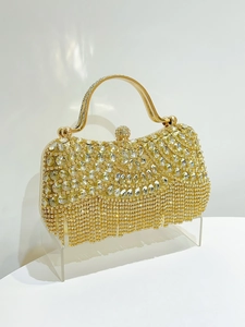 Detail of luxury gold evening clutch bag with sparkling rhinestone floral patterns and tassel