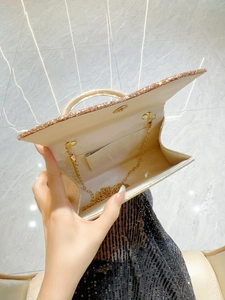 Sparkling gold sequin evening clutch bag with round metal handle and chain strap