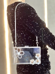 Detailed view of luxury transparent acrylic evening clutch with rhinestone floral accents