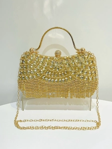 Detail of gold crystal evening clutch featuring radiant rhinestone flower and tassel