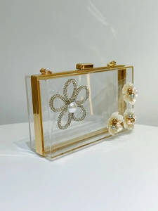 Detailed view of floral rhinestone and pearl embellishments on acrylic evening clutch