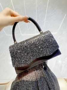 Detail of black sequin evening bag with rigid round handle and sparkling texture