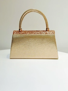 Detailed close-up of golden sequined evening clutch bag with circular top handle