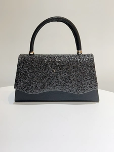 Close-up of black sequin evening bag with silver metal ball hinges and round handle