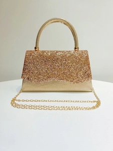 Detail view of champagne gold sequined evening clutch bag with elegant metal handle
