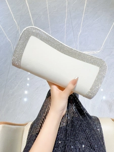 Dettaglio della pochette da sera in tessuto bianco con bordi di strass scintillanti