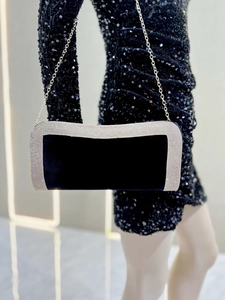 Dettaglio pochette da sera in velluto nero con bordi in strass e catena argentata sottile