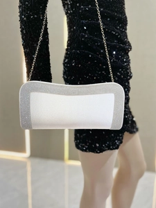 Dettaglio pochette da sera crema con strass argentati e sottile tracolla a catena dorata